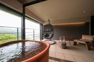 Hotel Higashidate في يامانوتشي: حوض استحمام في غرفة مع نافذة كبيرة