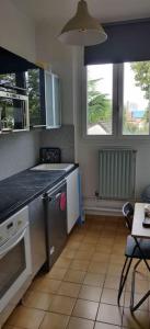 a kitchen with a sink and a stove top oven at Cosy Appartement Paris Ouest in Suresnes