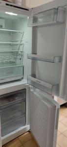 a refrigerator with its door open in a kitchen at Cosy Appartement Paris Ouest in Suresnes