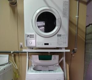 a washing machine with a mirror on top of it at Toyako Guest House Ponkotan in Lake Toya
