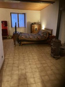 um quarto com uma cama e piso em azulejo em L'Escapade de JOS gite équestre em Pont-de-Salars
