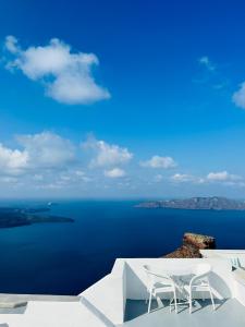 een uitzicht op de oceaan met twee stoelen op een richel bij La Roka, Cliffside Memories in Imerovígli