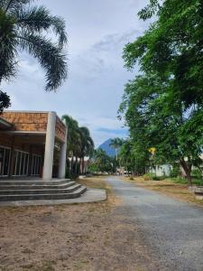 a building on a street with trees and a road at Casa Miguel Resort in San Bartolome