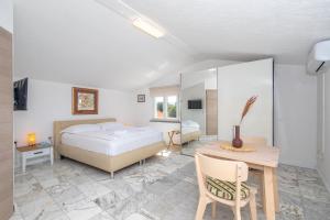 een slaapkamer met een bed, een bureau en een tafel bij Apartments Soul in Krk