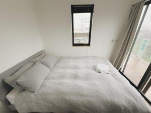 a white bed in a room with a window at 枕木 New house with Huge View for Family-Group in Tokyo