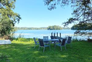 a table and chairs with a view of a lake at Seehaus Plön in Plön
