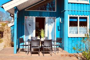 una casa azul con una mesa y sillas en un patio en Ferienpark - Komfort-Ferienhaus mitten in der Natur 5 Personen, en Extertal