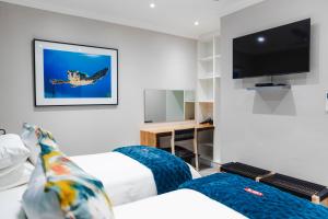 um quarto de hotel com duas camas e uma televisão de ecrã plano em 5 at Snapper em Meer en See