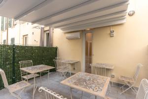 un patio con tavoli e sedie accanto a un edificio di Adam Eric a La Spezia
