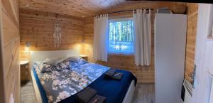 ein Schlafzimmer mit einem Bett in einer Holzhütte in der Unterkunft Domek Borsk in Borsk
