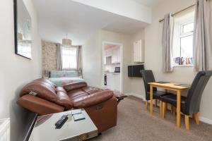 a living room with a couch and a table at Beachcliffe Holiday Apartments in Blackpool