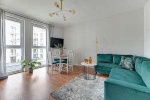 a living room with a green couch and a table at Aura 40 City Center by Downtown Apartments in Gdańsk