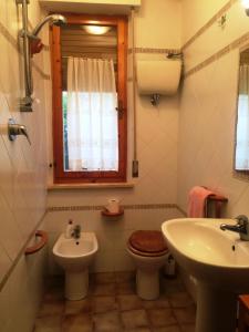 bagno con lavandino, servizi igienici e finestra di Appartamento TR a Follonica