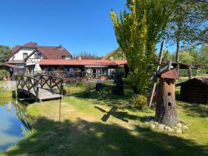 a garden with a bird house next to a lake at Pension Haus zum See GbR in Markische Heide