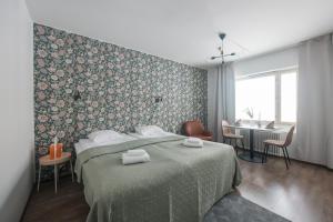 a bedroom with a bed with two towels on it at Forenom Serviced Apartments Helsinki Lastenkodinkuja in Helsinki