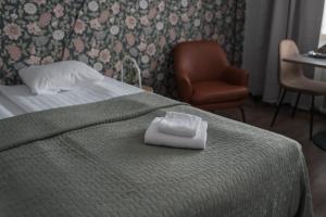a hotel room with a bed with a towel on it at Forenom Serviced Apartments Helsinki Lastenkodinkuja in Helsinki