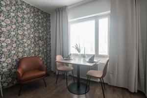 a dining room with a table and chairs and a window at Forenom Serviced Apartments Helsinki Lastenkodinkuja in Helsinki +24 photos