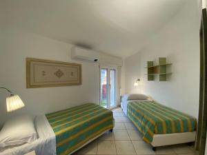Habitación de hotel con 2 camas y ventana en Locanda degli Artisti en Tortolì