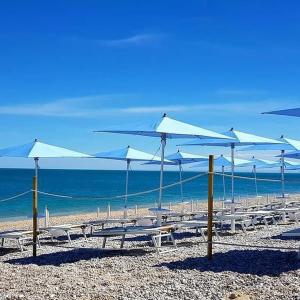 マッティナータにあるResidence Lido dei Piniの浜辺のテーブルと傘