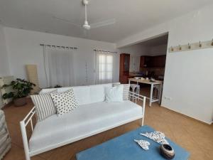 een woonkamer met een witte bank en een tafel bij ASIA in Ermoupoli