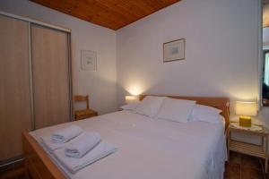 a bedroom with a white bed with towels on it at Stokic in Veli Lošinj