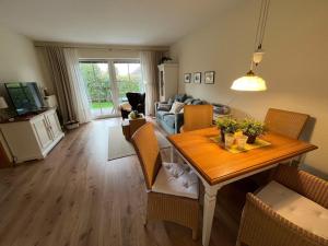 a living room with a dining room table and a couch at Ganterhals 4 Whg1 in Dahme