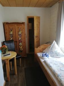a small room with a bed and a table and a table at Pension Haus zum See in Markische Heide