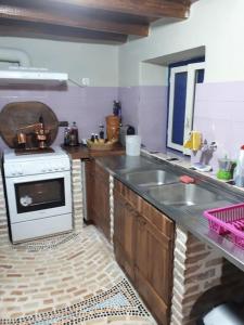 cocina con fogones blancos y fregadero en Κτήμα Archaia Ilida, en Avyíon