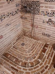 y baño con ducha y pared de azulejos. en Κτήμα Archaia Ilida, en Avyíon