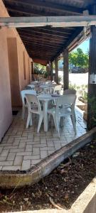 a group of white tables and chairs on a patio at U pozzu hôtel in Evisa