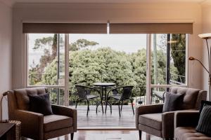 a living room with a balcony with a table and chairs at Seaside home with nearby beach access in Taroona
