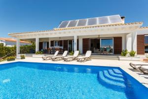 uma villa com uma piscina e uma casa em Bini Sole - Villa de lujo con piscina en Menorca em Binibeca