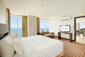 een hotelkamer met een bed en een flatscreen-tv bij Swiss-Belhotel Balikpapan in Balikpapan