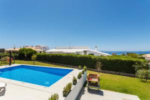 a swimming pool in the backyard of a house at Villa BINI SOLE in Binibeca