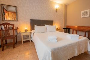 a bedroom with a large white bed with towels on it at La Asomada del Gato in La Laguna