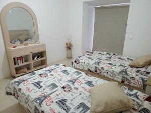 Mār YūsufにあるChaletapartment in Tilal Fanar resort,のベッドルーム1室(ベッド2台、鏡付)
