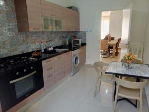 uma cozinha com uma mesa e um fogão forno superior em Chaletapartment in Tilal Fanar resort, em Mār Yūsuf