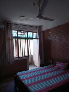 1 dormitorio con cama y ventana grande en Windy Hanthana, en Kandy