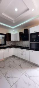 eine weiße Küche mit weißen Marmorböden und Geräten in der Unterkunft Villa mima in Houmt Souk
