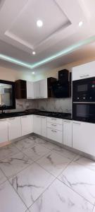 a white kitchen with white marble floors and appliances at Villa mima in Midoun