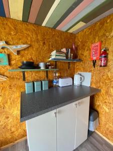 a kitchen with a counter and a yellow wall at Sunrise Cabin in Carbis Bay +31 photos