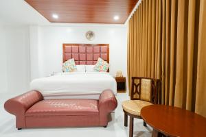 a bedroom with a bed and a chair and a table at Q Beach Resort in Cabangan