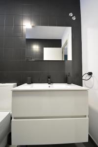 a bathroom with a white sink and a mirror at Roma's Apartment in Cambados