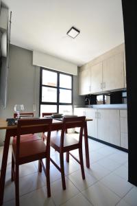 a kitchen with a wooden table and chairs and a dining room at Roma's Apartment in Cambados +20 photos