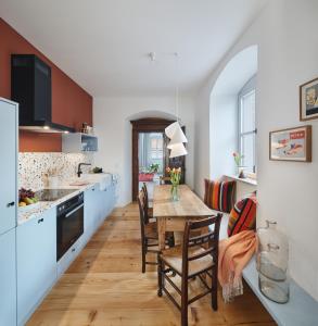 cocina y comedor con mesa de madera y sillas en Engelwirt Apartments en Berching