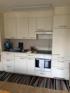 a kitchen with white cabinets and a stove top oven at Bad Ragaz Appartement in Bad Ragaz +7 photos
