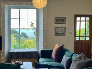 a living room with a blue couch and a window at 3 bedroom stunning house with garden and amazing sea views in Dartmouth