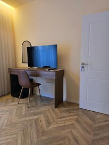 a desk with a monitor and a chair in a room at In Town Boutique HOTEL in Pristina