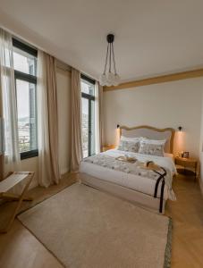 a bedroom with a large bed and large windows at EPICURE SUITES in Kavala