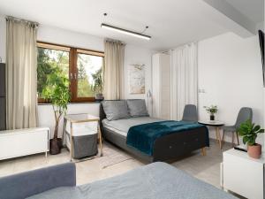 een slaapkamer met een bed, een bank en een tafel bij Novinea Apartamenty 